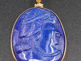 un pendentif en or et lapis-lazuli représentant une femme coiffée d'une parure de tête