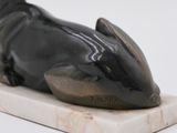 statue of a mouse on a marble base on a white surface