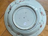 a blue plate with flowers on it sitting on a wooden floor
