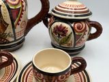a tea pot, cup, saucer, and saucer on a table