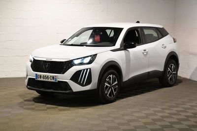 Le SUV blanc est garé dans une grande pièce au sol carrelé en damier.