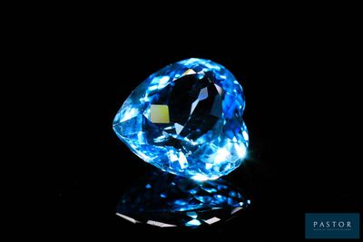 a close up of a blue diamond on a black surface