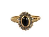gros plan d'une bague en or avec une pierre noire