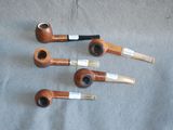 four pipes are lined up in a row on a gray surface
