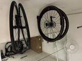 two bikes hanging on the wall next to a fan