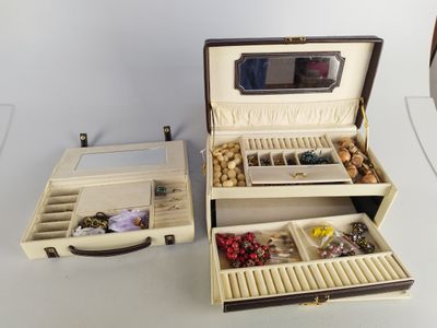 deux boîtes ouvertes contenant des bijoux, posées sur une table