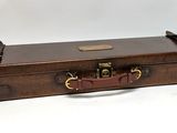 a wooden case with a handle on it on a white surface