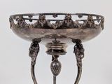 a silver bowl with a lion head decoration on it