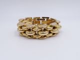 a close up of a gold bracelet on a white surface