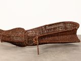 an image of a wicker couch sitting on top of a cement floor