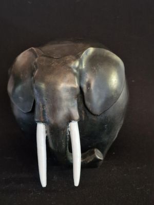 statue d'un éléphant avec des défenses sur fond noir