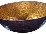 a black and gold bowl sitting on a white surface