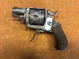 un vieux pistolet avec une étiquette, posé sur une table
