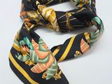 a black and yellow scarf with a floral design on it