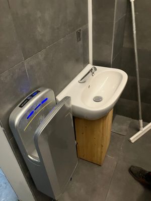 a small bathroom with a toilet, sink, and shower