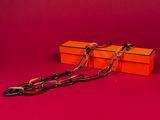 orange box with a chain attached to it on a red background