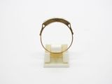 a close up of a gold ring on a marble stand