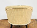 an upholstered chair sitting on top of a hard wood floor