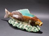 a figurine of a fish that is sitting on a wave