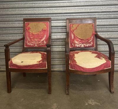 deux chaises recouvertes d'un tissu rouge et doré, placées devant un mur métallique