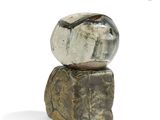 a small rock sitting on top of a piece of wood