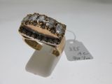 gros plan d'une bague en or avec des diamants sur une surface blanche