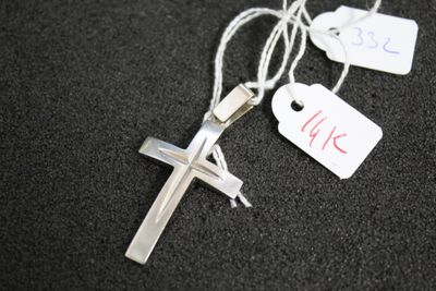 une croix en argent à laquelle est attachée une étiquette de prix