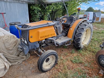 un tracteur garé devant un bâtiment, recouvert d'une bâche