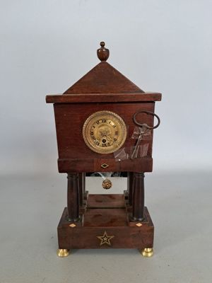 a small wooden clock that is sitting on a table