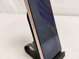 a close up of a cell phone on a stand on a white surface