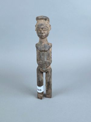 une vieille statue en bois d'un homme avec un chapeau sur la tête