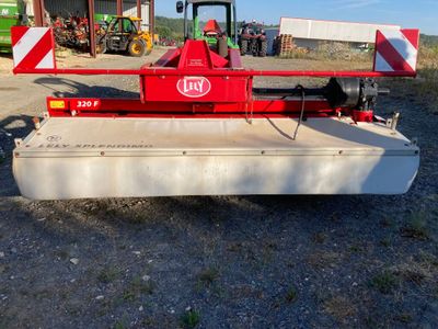une image représentant un tracteur rouge équipé d'une grande lame