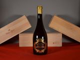 a bottle of wine sitting on a table next to two wooden boxes