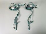 two metal birds that are sitting on a wall