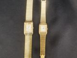 deux montres en or posées sur un tissu noir