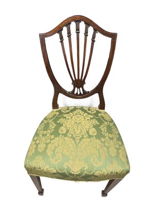une image représentant une chaise dont l'assise est recouverte d'un tissu vert et doré
