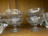 many glass bowls and glasses on a shelf