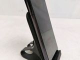 the phone is sitting on the stand on the table