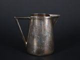 an old silver pitcher on a black background with a black background