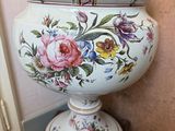 a large vase with a lid on a wooden stand
