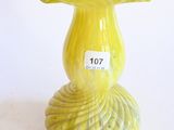 un vase jaune sur lequel est collée une étiquette blanche