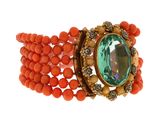 an image of an orange bracelet with a green stone center