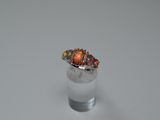 an orange fire oplite ring sitting on top of a glass of water