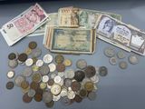 a pile of money and coins on a table next to a laptop