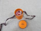 a small orange bucket with a purple ribbon and a small orange container with a purple ribbon
