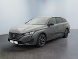 Une voiture grise est garée dans une pièce aux murs blancs.