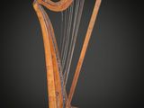 une harpe en bois posée sur un support, sur fond noir