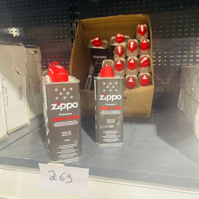 two cans of zippo on the shelf of a store
