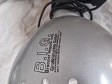 a close up of a silver electric fryer on a white sheet