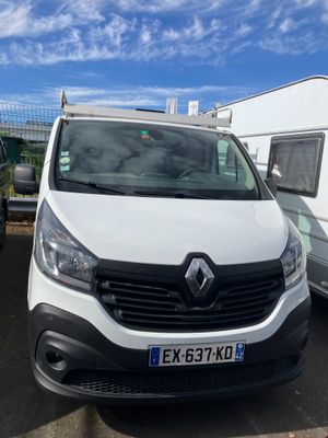 La camionnette blanche est garée à côté de la remorque sur le parking.
